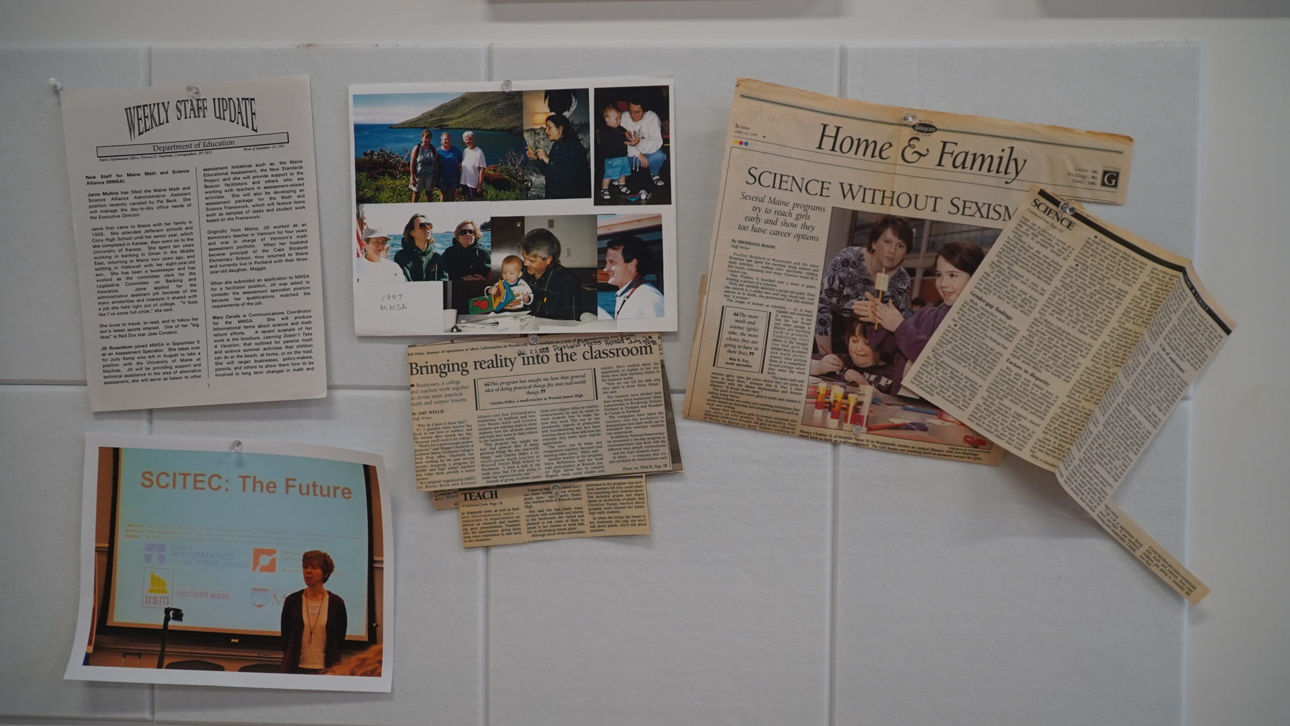 A photo of a powerpoint presenter, past staff photos, and more newspaper clippings hung on the wall for the 30th anniversary event.
