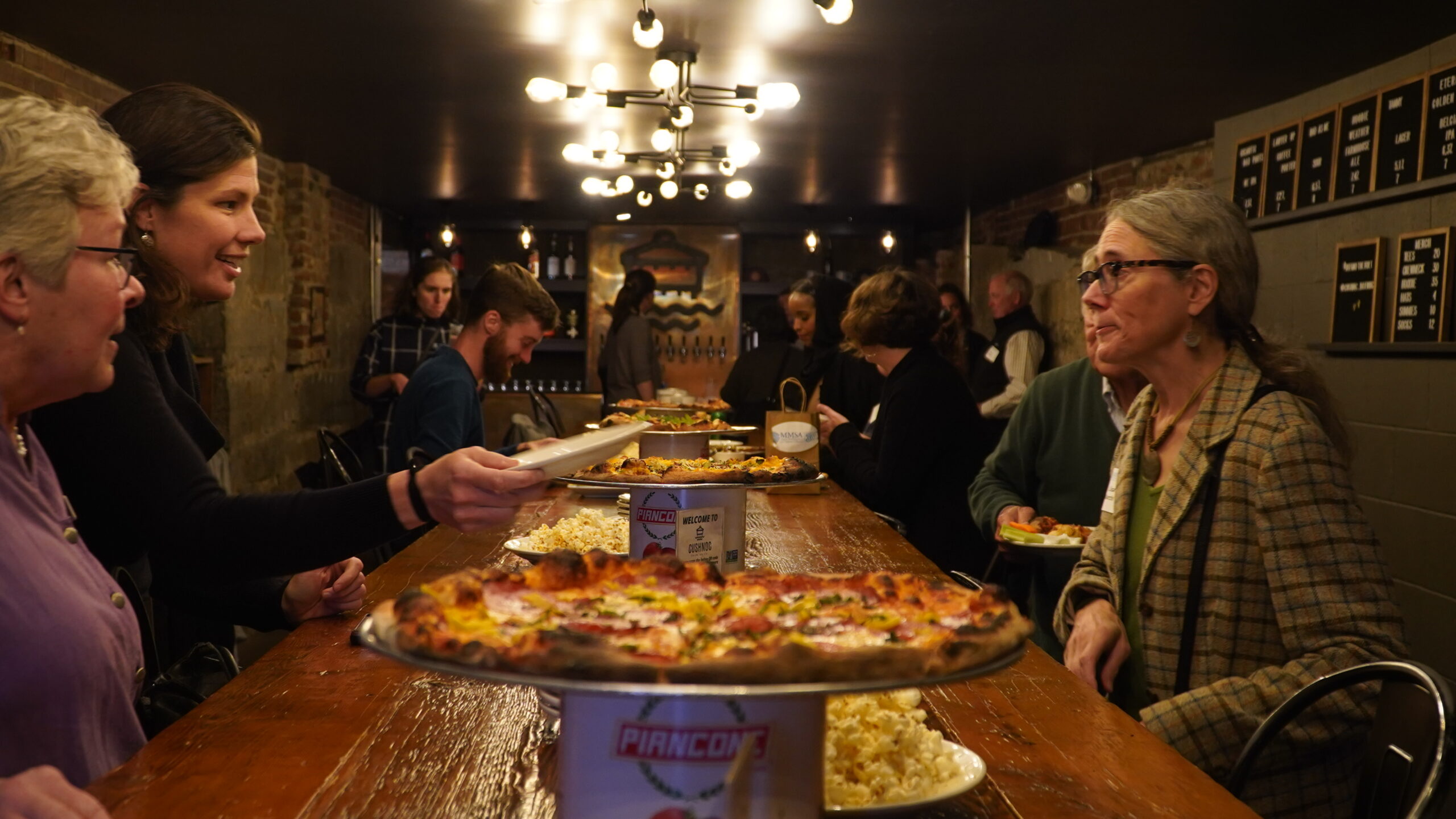 Attendees to the second part of the night's events sit on either side of a long table at Cushnoc.