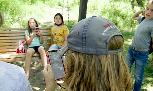 Kids use the STEM ports app outside in summertime.