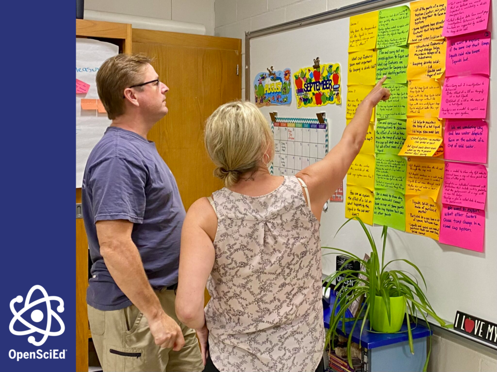 Two adults review a board on a wall with sticky notes of various colors arranged in columns. There is an overlay on this image showing the Open Sci Ed logo.
