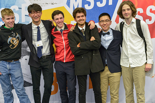 Six students stand in front of a backdrop showing the high school science fair logo.