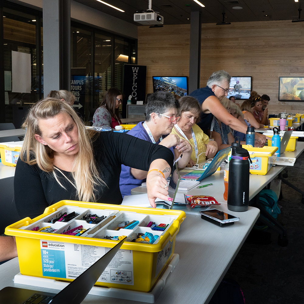 Educators work with robot parts.