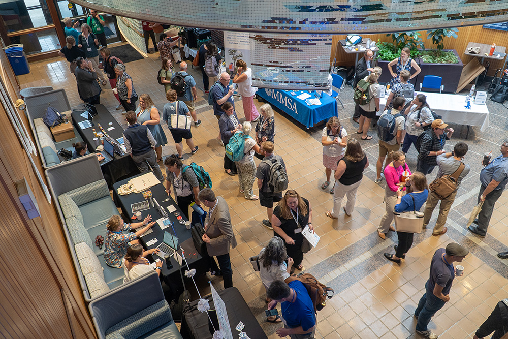 A bird's-eye view of participants mingling in a conference hall.