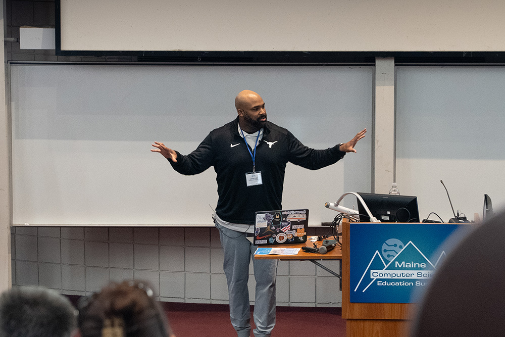 Dr. Joshua Childs is shown on stage gesturing as part of the speech he gave.