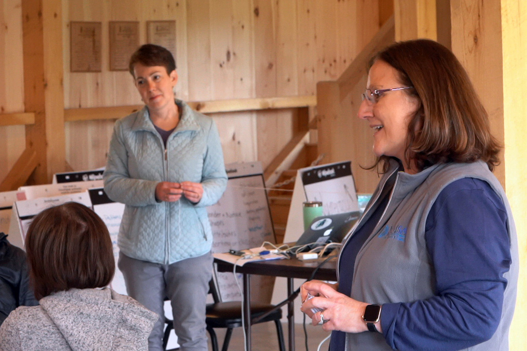 Two facilitators present inside of a wooden structure.