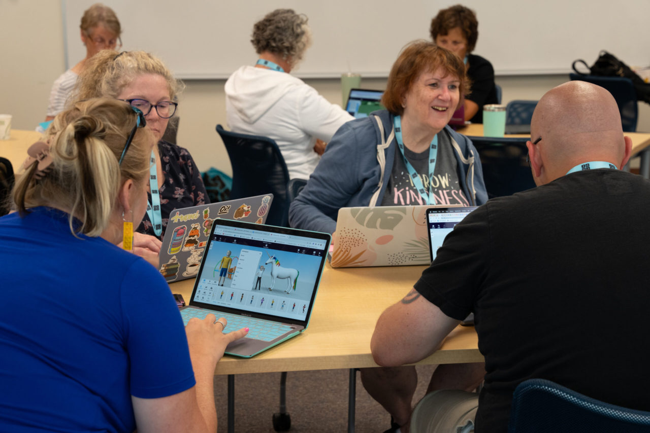 A group of educators mingle in a conference workshop setting.