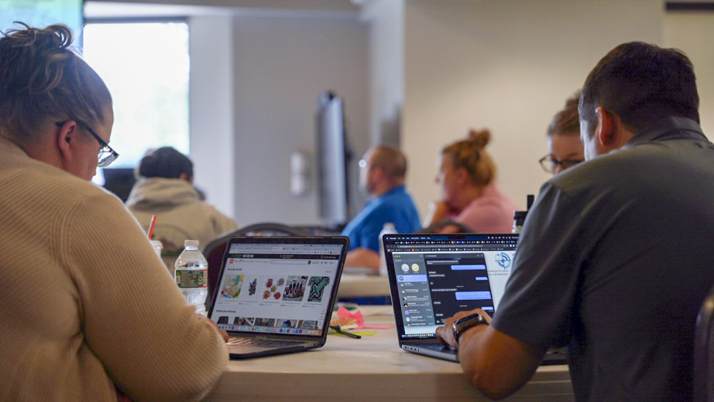 A photo showing two educators using laptops.