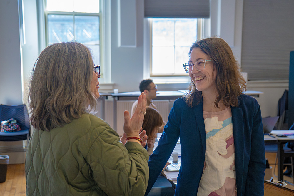 An ACRES staff person converses with an ACRES coach in a conference room.
