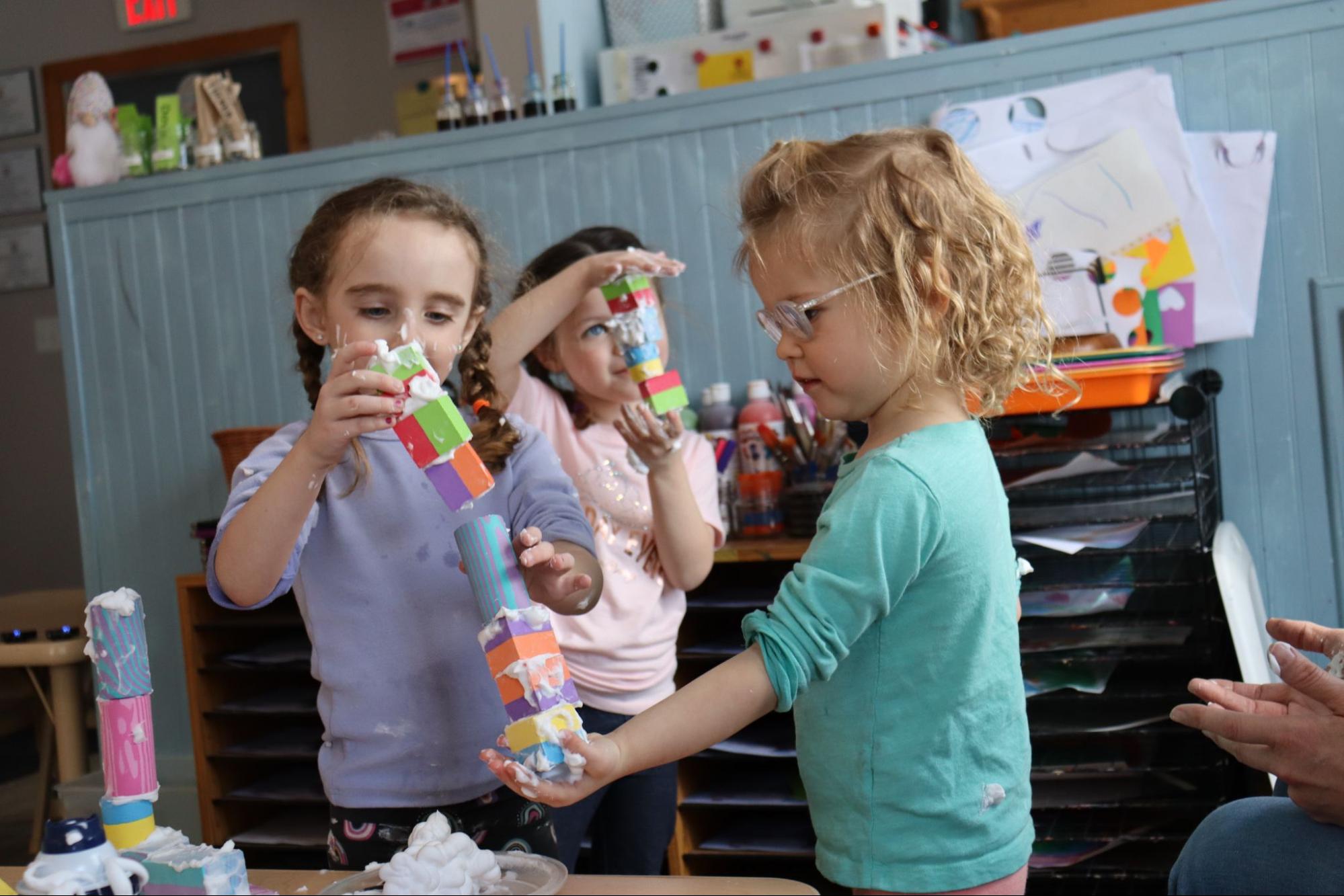 Young children play with blocks in a classroom.