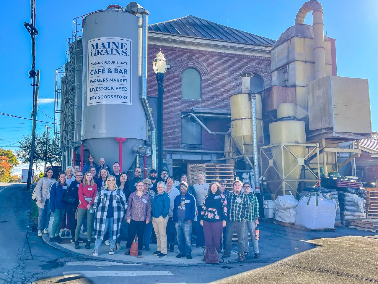 A group of educators pose outside in front of the Maine Grains headquarters in Skowhegan, Maine.