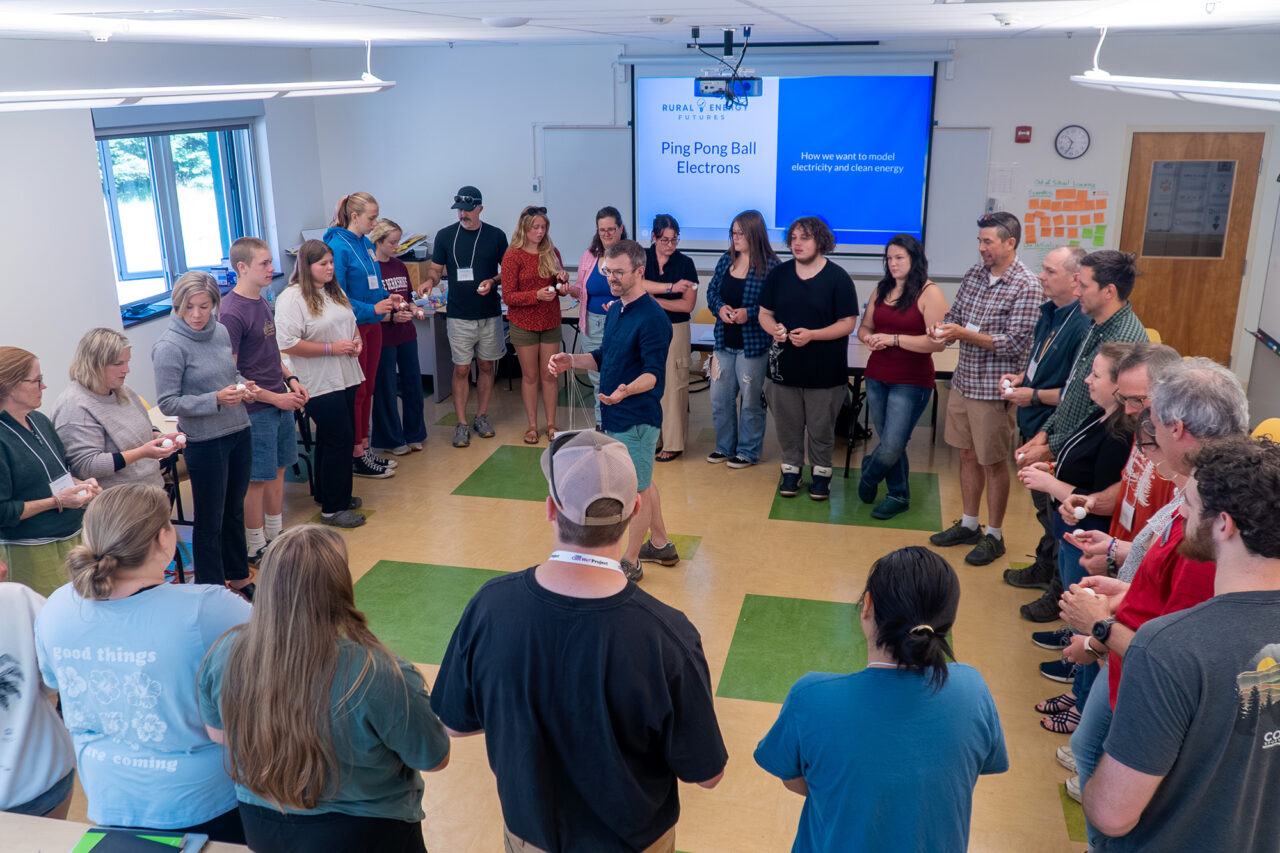 MMSA STEM specialist Terence Finnegan leads a group of mentors, educators, and students in a group activity about the flow of electricity.
