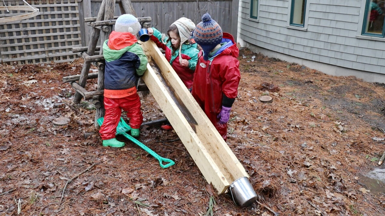 A play-based science scenario from the article: children explore and compare the different properties of mud and water as they make observations, investigate the outcomes of pouring mud versus water, and analyze the results.